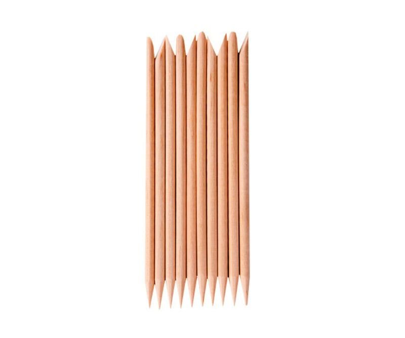 Zehn ordentlich angeordnete Holz-Nagelhautstäbchen mit spitzen Enden – ein unverzichtbares Werkzeug im UNIQ Nail Starter Kit: Komplettes Gel-Nagelset mit 80-W-UV/LED-Trockner von UNIQ, perfekt für die Vorbereitung der Nägel vor dem Aushärten unter Ihrer Lampe.