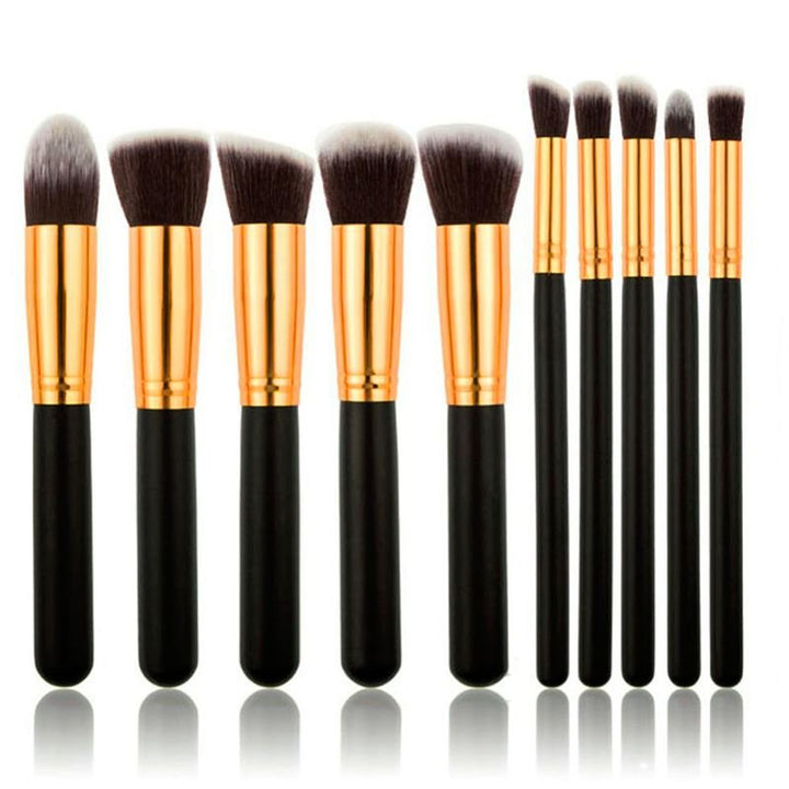 The PRO Makeup Brush Set Black/Gold by PRO includes 10 premium kabuki and precision brushes with black handles, gold ferrules, and soft bristles, all upright in a row against a white background for flawless application.