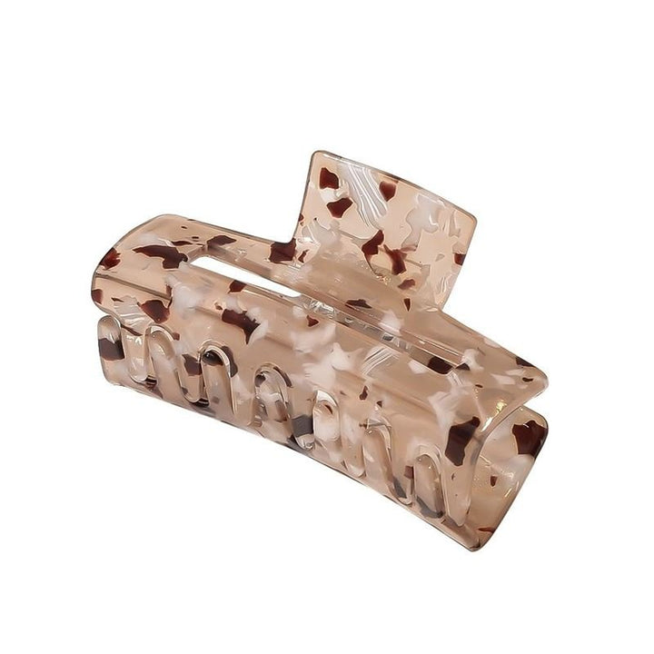 The SOHO Aria Hair Claw - Light Tortoise features a beige and brown tortoiseshell acetate design with curved edges and interlocking teeth, made by SOHO to securely hold thick hair in place.