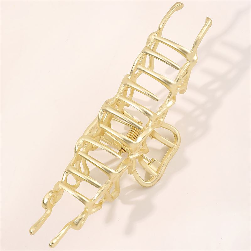 Die SOHO Asli Metal Hair Claw – Silver von SOHO zeichnet sich durch ein geometrisches, leiterartiges Design aus. Vor einem hellen Hintergrund präsentiert, hebt dieses elegante Accessoire seine federnde und gezackte Metallstruktur hervor.