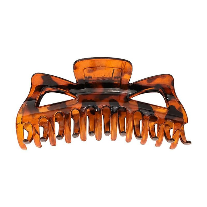 The SOHO Astrid Hair Claw - Tortoise by SOHO is a strong, tortoiseshell-patterned clip with interlocking teeth and spring hinge, designed to securely hold thick hair in place all day.