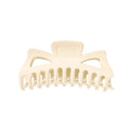 The SOHO Astrid Hair Claw - White by SOHO is a large plastic hair clip featuring wide, curved teeth and two triangular cutouts near the top—ideal for securing thick hair.