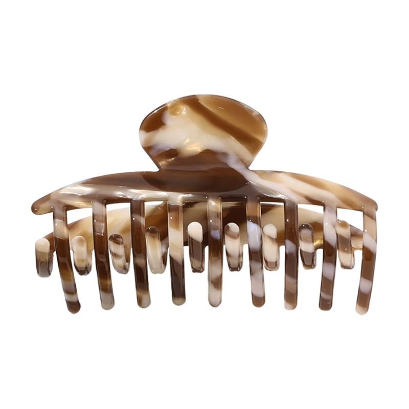 The SOHO Gaja Hair Claw in Brown Marble features wide, curved teeth and a rounded top—perfect for securing updos in style.