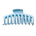 The SOHO Kana Hair Claw in light blue features wide, curved teeth for a strong grip and suits all hair types. Shown against a white background.