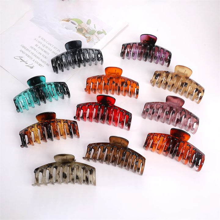 Zehn SOHO Kana Hair Claw – Schildpatt-Clips von SOHO, die für alle Haartypen geeignet sind und einen starken Halt bieten, sind in Reihen auf einer weißen Fläche angeordnet. Diese farbenfrohen Clips sind in den Farben Schwarz, Blaugrün, Rot, Rosa, Braun, Bernstein, Orange und Schildpatt erhältlich.