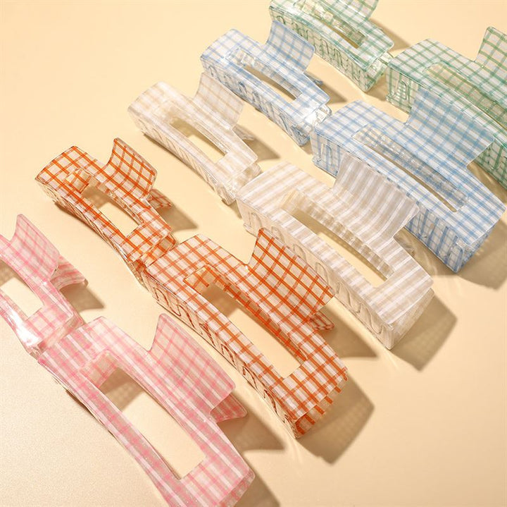 The SOHO Line Hair Claw in green by SOHO features a rectangular chequered design, offering a secure hold and effortless styling for your hair.