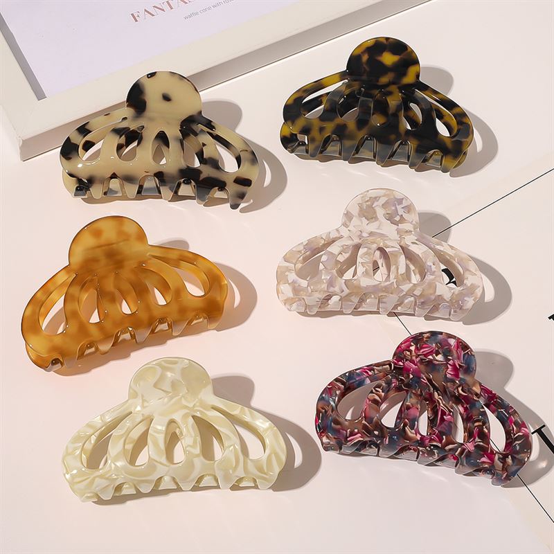 Six large SOHO Olivia Hair Claw - Marble clips in assorted marbled shades, including tortoiseshell, amber, and pink-purple, are neatly arranged in two rows, creating a stylish SOHO hair accessory set.