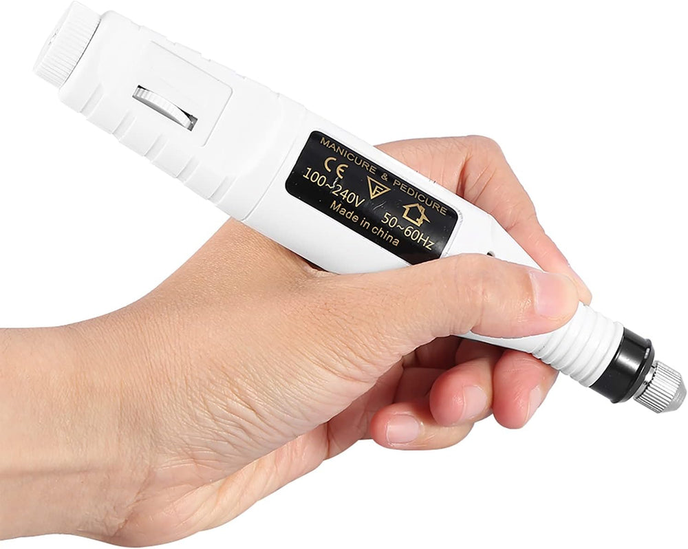 A hand holds the UNIQ Basic 6-in-1 Electric Nail File in white, a cylindrical nail drill kit with a black and gold UNIQ label and an adjustment dial—an essential tool for any manicure set.
