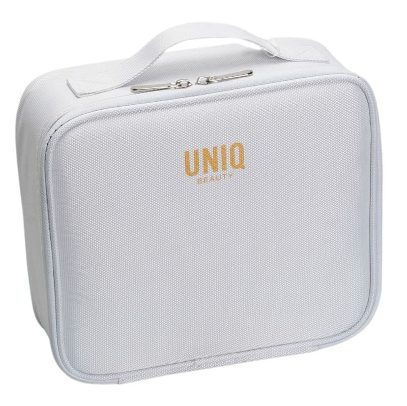 The UNIQ makeup travel bag is a white rectangular cosmetic bag with a top handle, gold UNIQ branding, and adjustable compartments for versatile storage.
