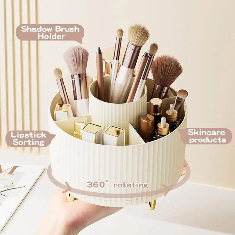 A hand holds the UNIQ Rotating Makeup Organiser in Cream White by UNIQ, featuring labeled sections for brushes, lipsticks, and skincare. This stylish organiser spins 360° for easy access and elegant storage of all your beauty essentials.